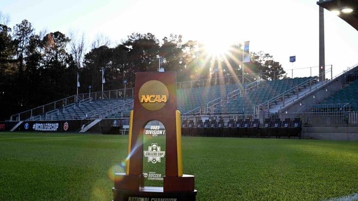 Trophée de soccer NCAA devant un terrain universitaire