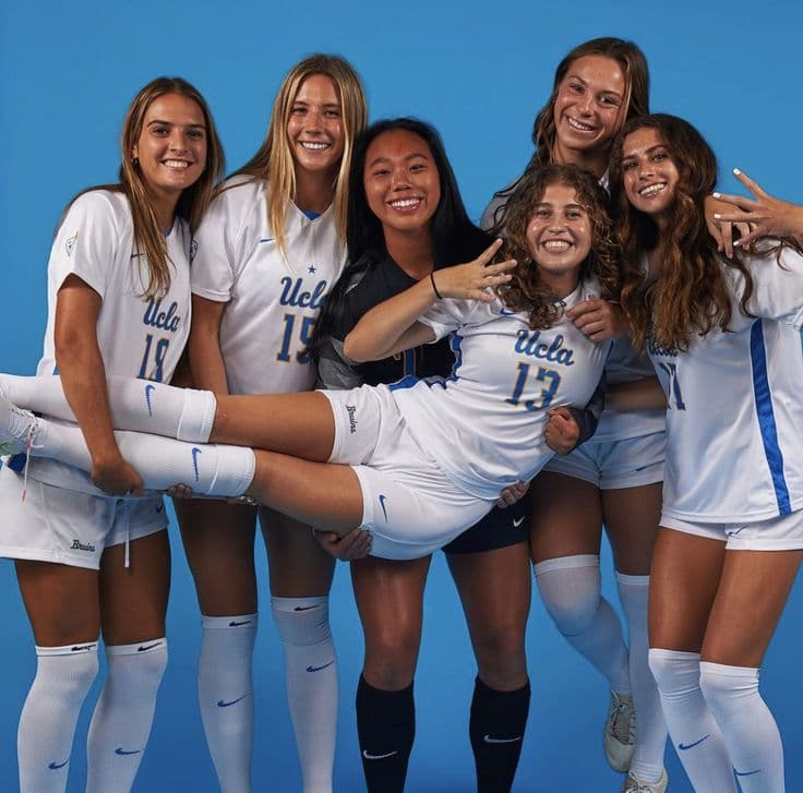 Joueuses en tenue de football posant ensemble devant un fond bleu