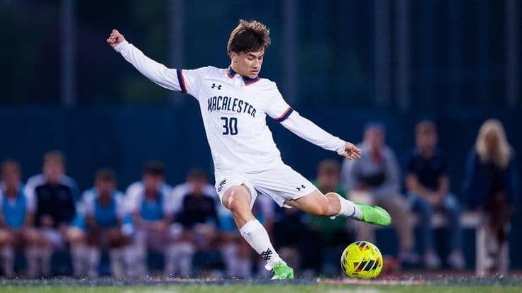 Joueur de Macalester College frappant le ballon pendant un match de football universitaire