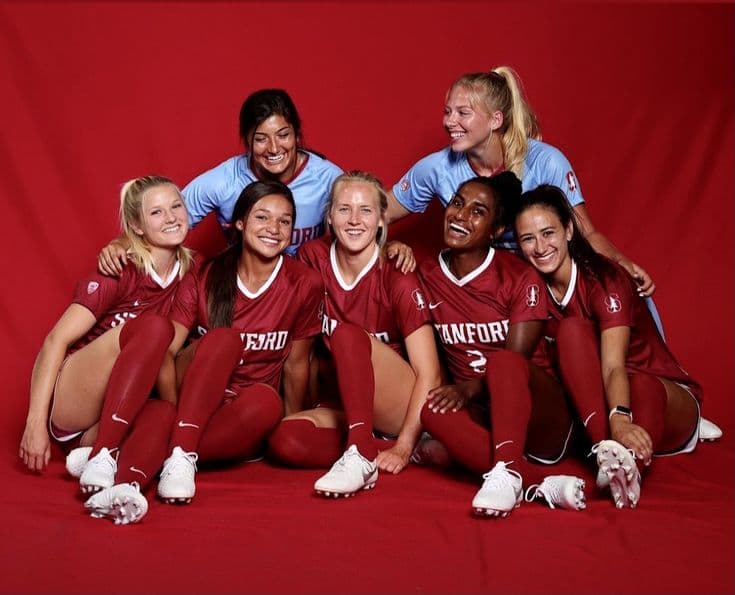 Joueuses en tenue de Stanford réunies pour une photo de groupe devant un fond rouge